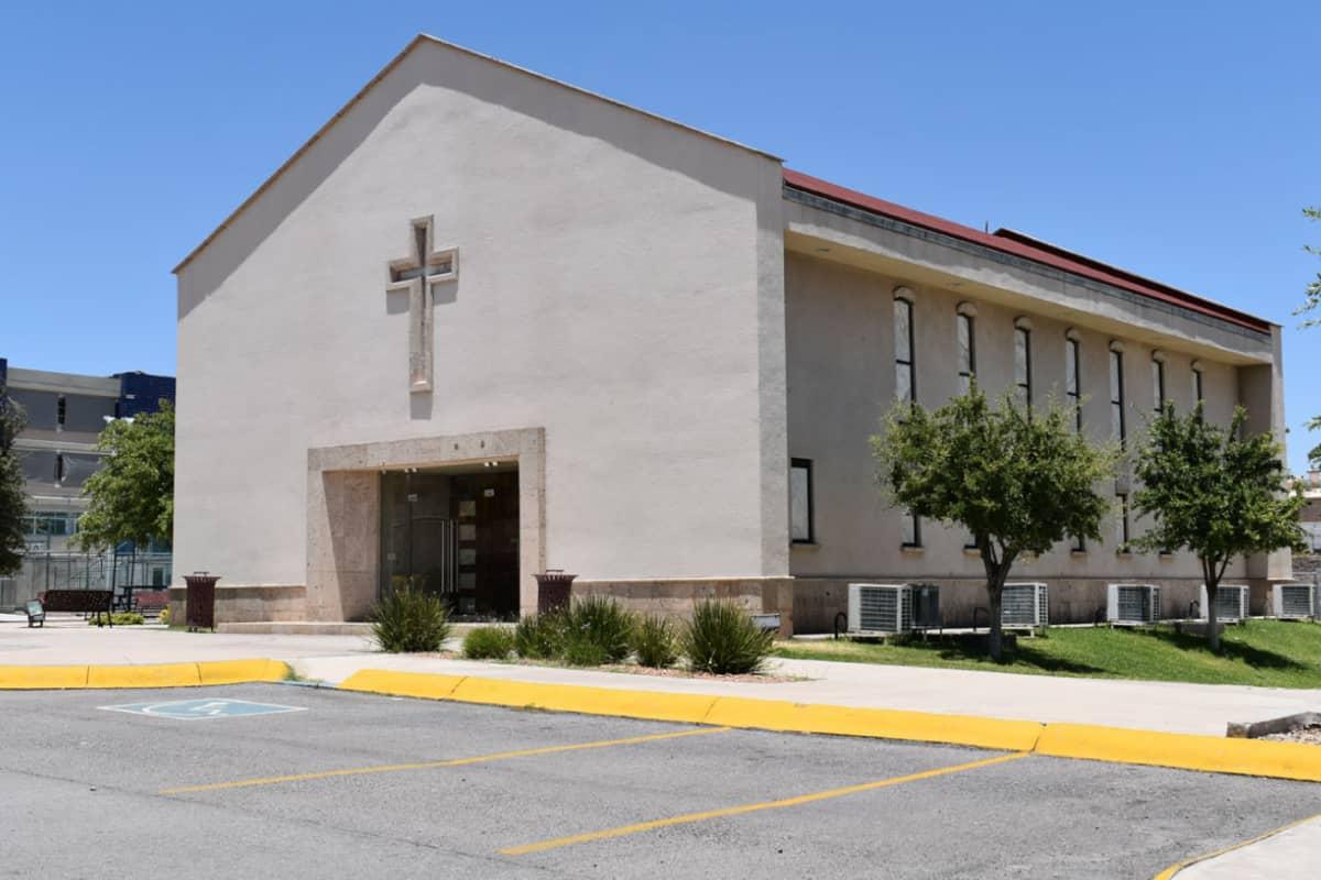 Fachada moderna del Colegio Everest con bloques de colores y estacionamiento, bajo cielo nublado.