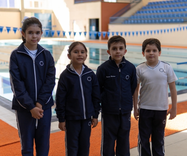 Alumnos de primaria Everest Chihuahua frente alberca de natación